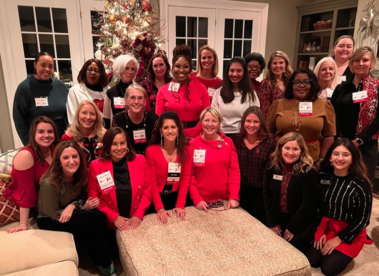 Circle of Red member in group photo around a Christmas tree.